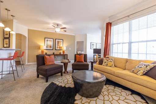 A living room with a brown sofa, a brown armchair, and a brown coffee table.