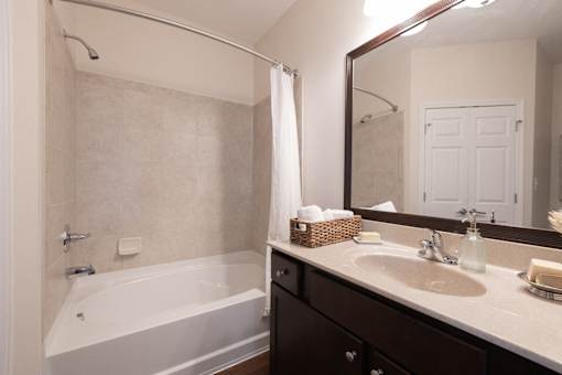 A bathroom with a white tub and sink.