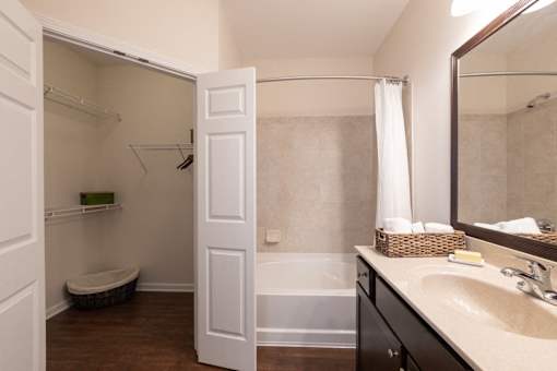A white bathroom with a white door open to a white shower.
