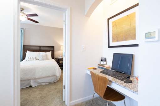 A bedroom with a bed, desk, and chair.