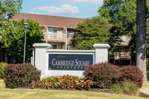 Apartment community entrance sign with flower beds at  Cambridge Square Apartments in Beech Grove, IN