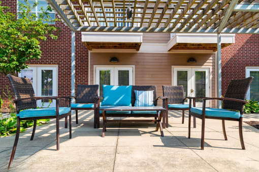 Inviting outdoor terrace at Arden Woods, featuring comfortable seating and a pergola, perfect for relaxation and gatherings.