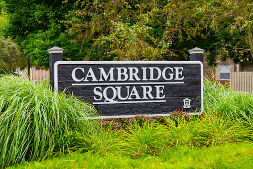 A black sign with white lettering that says "Cambridge Square".