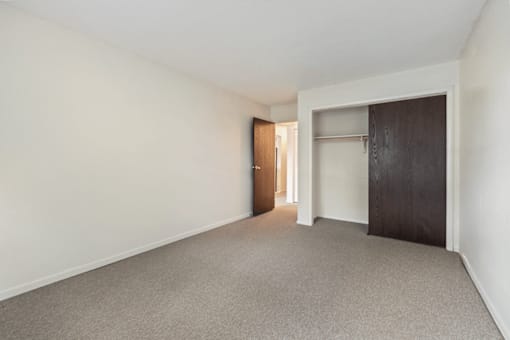 A room with a carpeted floor and a door on the right.