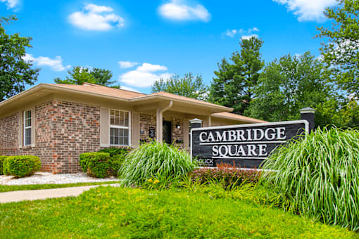 A house with a sign that says Cambridge Square in front of it.