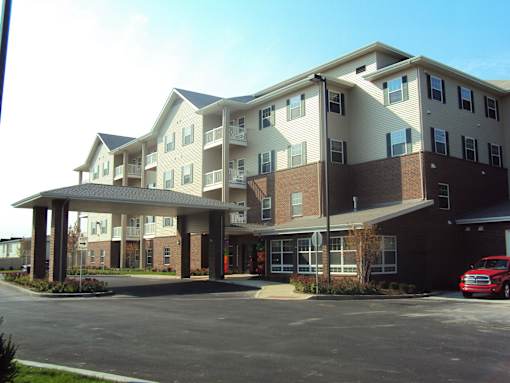 A large apartment building with a parking lot in front.