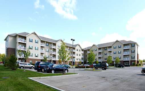 A parking lot in front of apartment buildings.