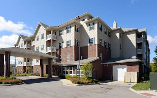 A large apartment complex with a parking lot in front.
