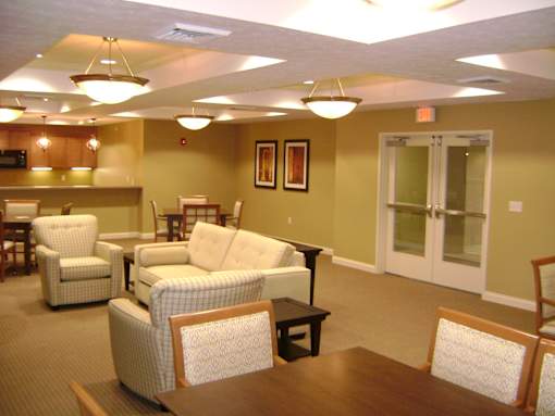 A room with a brown table and white chairs.