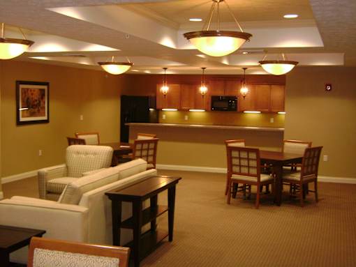 A living room with a couch, chairs, and a television.