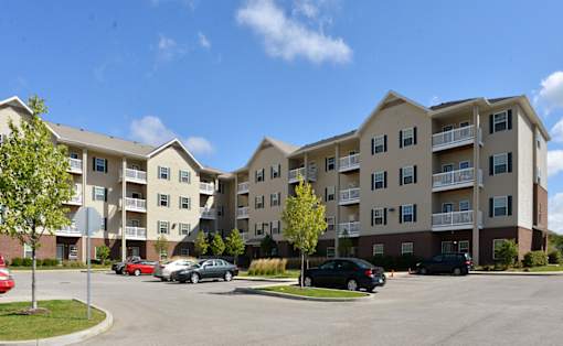 Apartment complex with cars parked in front.