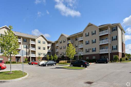 Apartment complex with cars parked in front.