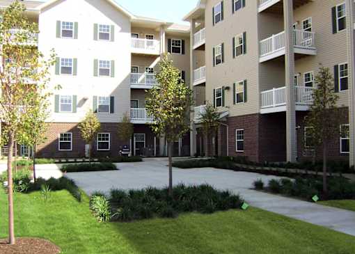 Apartment complex with a courtyard and trees.