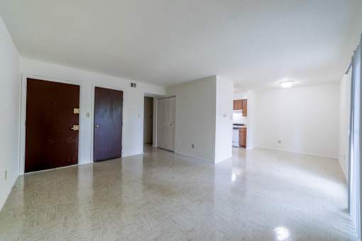 A large empty room with a wooden floor and white walls.