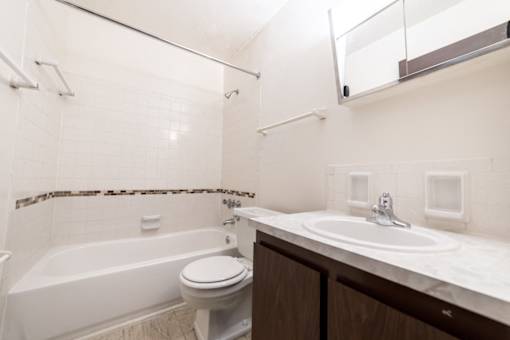 A white bathroom with a toilet, sink, and bathtub.