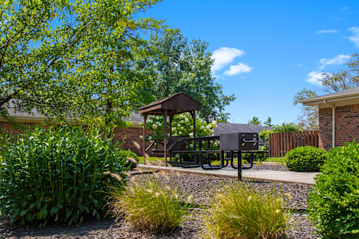 BBQ and picnic area at Fairington Apartments in Lafayette, featuring grills, picnic tables, and a landscaped outdoor space.