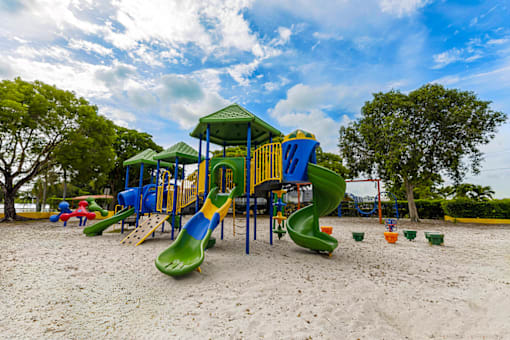 Playground at Cambridge Square Apartments in Lauderdale Lakes, featuring colorful play structures with slides.