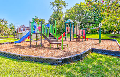 Playground at Hampton Place Apartments, featuring slides, and open space for outdoor activities.