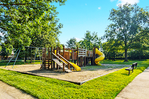 Playground at Jamestown Apartments in Seymour, Indiana, with slides, swings, and open space.