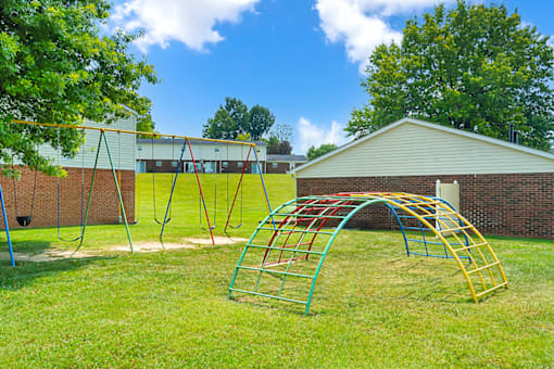 Playground at Valley Ridge Apartments featuring colorful play structures, swings, and a play area.