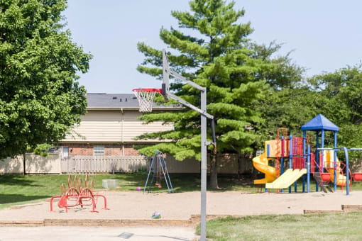a playground with a swing set and a basketball hoop