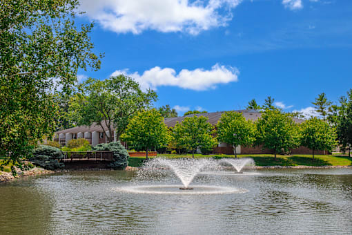 Pond at Fairington Apartments in Lafayette, surrounded by lush landscaping.