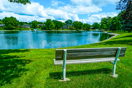 Tranquil pond at Jamestown Valparaiso, with park bench seating surrounded by vibrant greenery.