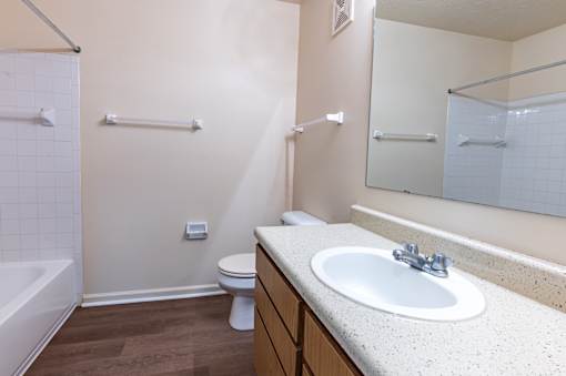 A bathroom with a white sink, toilet, and bathtub.