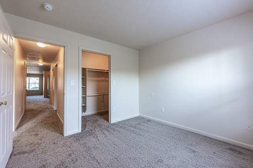 A long hallway with a door on the left and an open door on the right.