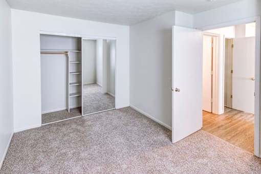 Primary bedroom in a 2-bedroom, 1-bath apartment at Woodland Crossing, offering neutral walls and carpeted flooring.