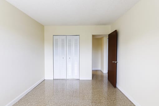 Primary bedroom in a 2-bed, 1-bath apartment at Cambridge Square Apartments in Lauderdale Lakes, featuring a closet for convenient storage.