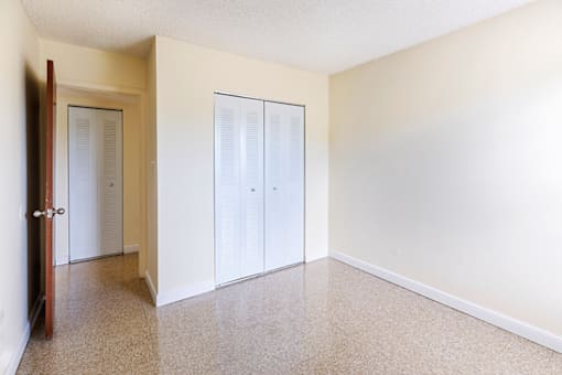 Secondary bedroom in a 2-bed, 1-bath apartment at Cambridge Square Apartments in Lauderdale Lakes, featuring a closet for convenient storage.