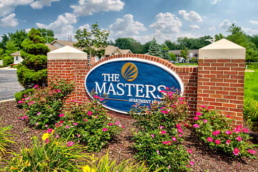 The sign for The Masters Apartment is blue and white with a gold logo.