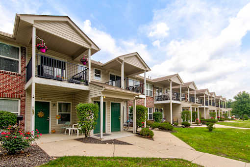 A row of townhouses with green doors and white trim.
