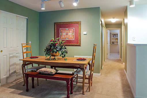 A dining room with a wooden table and chairs.