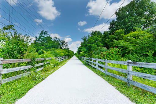 Walking trail at Northwood on the Trail, surrounded by trees and greenery, perfect for outdoor recreation and relaxation.