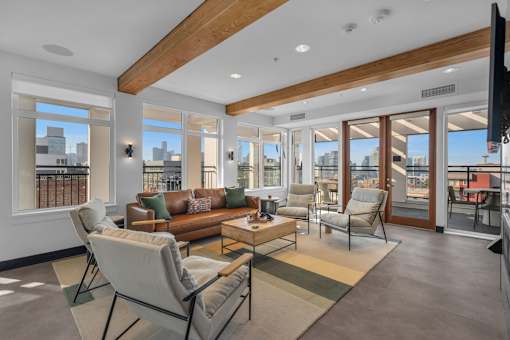 Spacious living room with wood beams and patio access at The Lyric Apartments, Seattle, WA