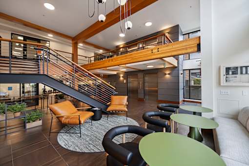 Modern lobby with staircase and seating areas at The Lyric Apartments, Seattle, WA 98102