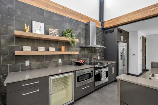 Modern kitchen with dark tile backsplash at The Lyric Apartments, Seattle, 98102
