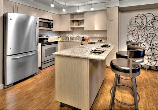 Contemporary kitchen with island seating and stainless appliances at The Lyric Apartments, Seattle, Washington