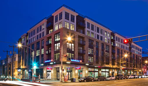 Contemporary brick building exterior at twilight at The Lyric Apartments, Seattle, WA 98102