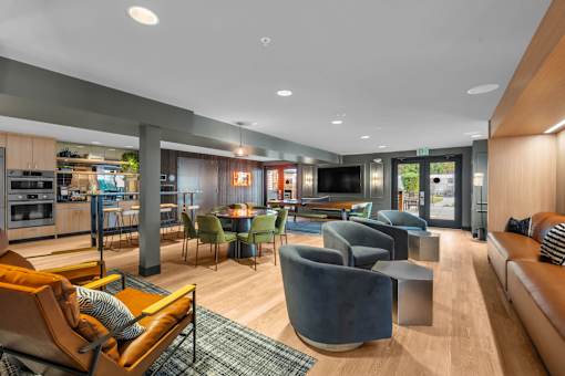 Open plan clubhouse with kitchen and lounge seating at The Lyric Apartments, Seattle, 98102