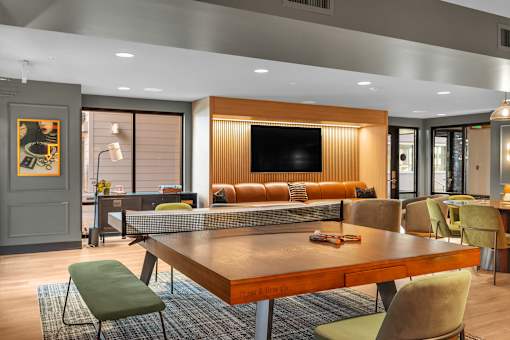 Game room with ping pong table and lounge seating at The Lyric Apartments, Seattle