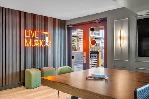 Recreation room with ping pong table and neon sign at The Lyric Apartments, Washington