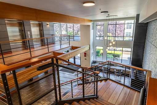 Multilevel lobby with wood accents and modern railings at The Lyric Apartments, Seattle, WA 98102