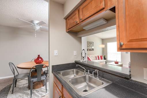 A kitchen with a table and chairs and a sink.