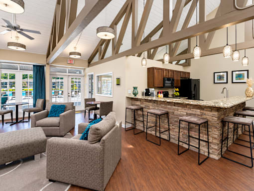 A living room with a bar and a kitchen area.