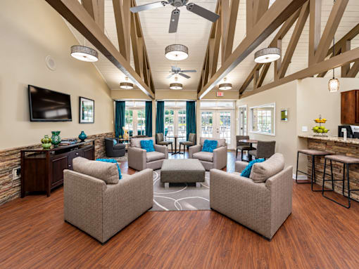 A living room with a brown wooden floor and a ceiling fan.