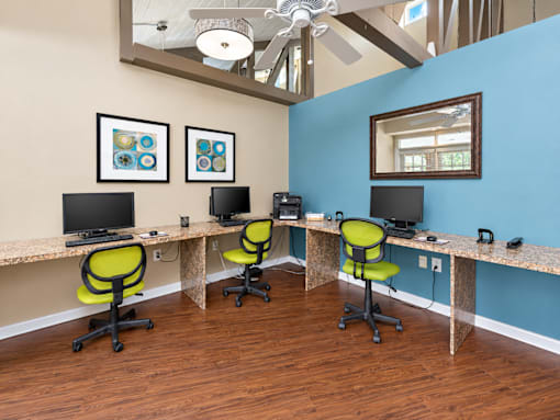 A room with a blue wall and a desk with two chairs.