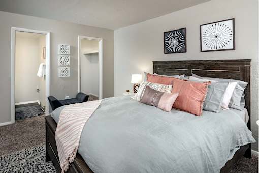 A bedroom with a large bed and two wall art pieces.